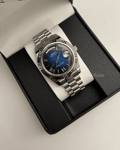 Day-Date (Blue Roman) Japanese automatic mod watch. A watch in a box with a blue dial and silver fluted bezel on a silver metal bracelet.