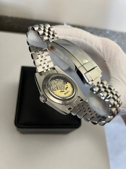 GMT (Bruce Wayne) Seiko NH34 GMT automatic mod watch. A caseback detail shot showing the internal movement of the watch with a silver metal bracelet.