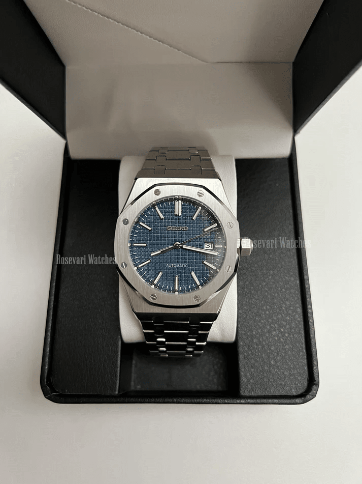 Royal Oak (Blue) Seiko NH35 automatic mod watch. A full watch shot inside a box showing a blue textured dial and silver bezel on a metal link bracelet.