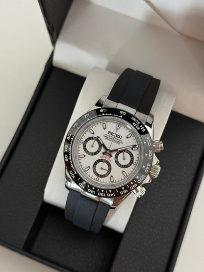 Daytona (Panda) Seiko VK63 meca-quartz chronograph mod watch. A high angle full watch shot in a box showing a white dial with black sub dials and a black bezel.