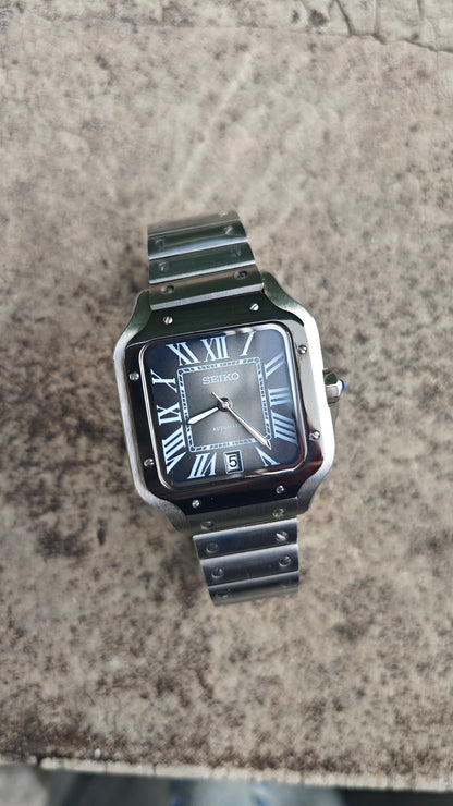 Santos (Graphite) Seiko NH35 automatic mod watch. A top down full watch shot showing a grey dial with a black bezel and a metal link bracelet.
